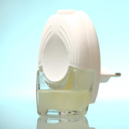 A white plug-in air freshener with a wick diffuser sits in front of a light blue background.