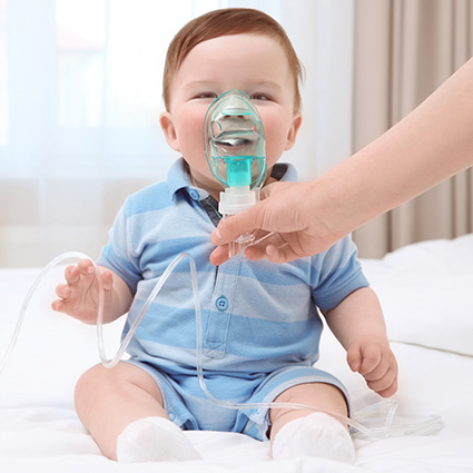 A parent helps a baby us a nebulizer for therapy